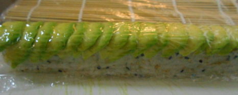 adding avocado sushi roll